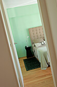 Blick auf das Bett im grünen Zimmer durch die Schlafzimmertür