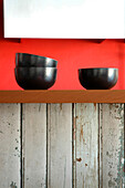 Black bowls on recycled kitchen counter with Lapacho top and plastered walls painted red