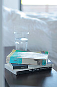 Buch und ein Glas Wasser auf einem Nachttisch