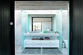 Schiebetür zum Badezimmer mit abgeschirmtem Waschbecken aus Carrara-Marmor und eingelassenem Spiegel unter Oberlicht mit Quarzlampen
