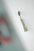 Rope tassel door pull on panelled cupboard