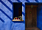 Blue painted stucco porchway with heavy wooden door
