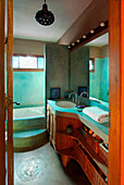 Aquamarine bathroom with wood furniture and shelves wicker baskets and concrete counter