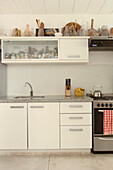 White kitchen with utensils stored above wall mounted cupboard