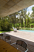Poolside terrace with chairs set in woodland