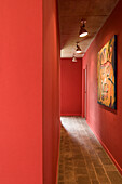 Red hallway with spot lit artwork