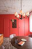Circular table in red living-room with ceiling light