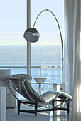 20th century Designed recliner at window with metal lamp and view to sea