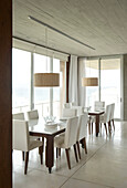 All white dining room with pendant lights and floor to ceiling windows