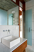 Rectangular basin on marble wash stand below mirror