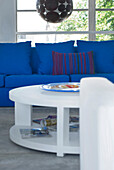Circular coffee table with vibrant blue sofa