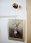 Artwork of angel hanging from brass door knob