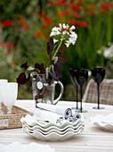 Schnittblumen und Weingläser auf einem Tisch im Landhausstil