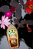 Toy boat flowers and leaves floating on water surface