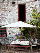 Parasol shades table outside stone building exterior