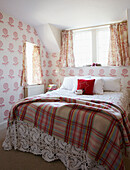 Karierte Decke auf einem spitzenbespannten Bett im Schlafzimmer mit passenden Vorhängen