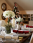 Centre piece flower arrangement and crackers on table set for Christmas dinner 