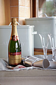Champagne bottle and glasses on a tray with silver crackers