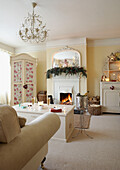Christmas garland above open fire in white country living room