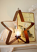 Lit candle in star shaped Christmas candle holder
