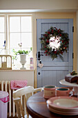 Sunlit kitchen with Christmas garland on blue painted back door
