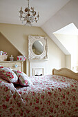 Floral patterned bedroom quilt in room with dormer window