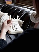 Woman talking on cream rotary dial telephone