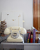 Cream rotary dial telephone with books and knitting spool