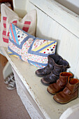 Children's boots and pillows on a bench in the bedroom