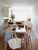 Light wood furniture in white sunlit kitchen 