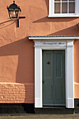 Sunlit painted house exterior and doorway 