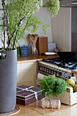 Vase mit Schnittblumen und Gemüsekiste auf Küchenarbeitsplatte in Suffolk