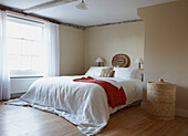 Weißer Bettbezug in einem sonnendurchfluteten Schlafzimmer mit Balken