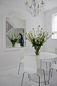 Woman's reflection in all white dining room mirror