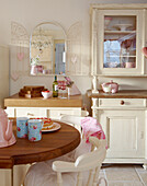 Cream painted kitchen with mismatched furniture and wooden worktops