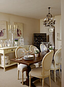 Dining room with metalworked chandelier and painted side table and chairs