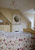 Floral patterned bed cover in bedroom with dormer window