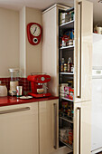 Red tiled kitchen with sliding pantry unit