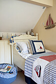 Painted single bed in boy's room with nautical theme