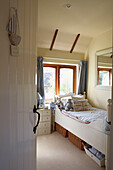 Single bed in child's room below sunlit window