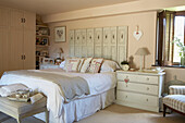Double bed with white bed linen and folding screen headboard