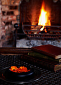 Books on coffee table with open fire in Georgian farmhouse 
