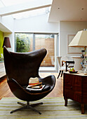 Brown leather armchair with sunhat in open plan apartment 