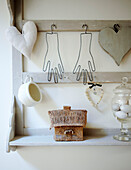 Thatched cottage and ornaments on wall mounted shelving unit