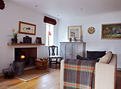Lit wood burning stove and sofa with woollen blanket