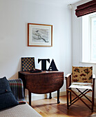 Oversized letters on folding table at window with fabric upholstered director's chair