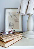 Reading glasses and books on bedside table