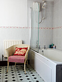 Red patterned cushion on cane chair in bathroom of Edwardian terraced house