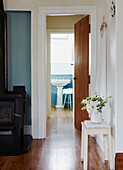 View through wooden door to turquoise panelled bathroom in Wairarapa home North Island New Zealand