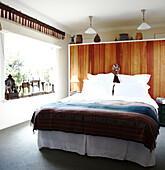 Doppelbett in sonnenbeschienenem getäfeltem Zimmer in Masterton, Neuseeland